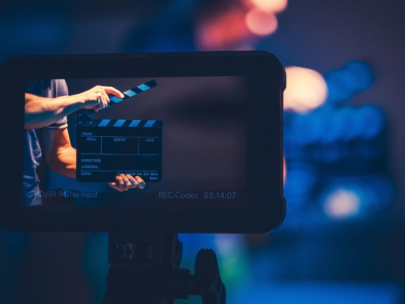 Film Production Reference Monitor. Modern Video Making Equipment. Men with Clapperboard on the Screen.